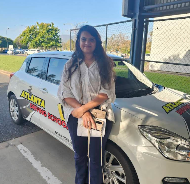 Atlanta Driving School instructor standing in front of the branded training car in Rockhampton